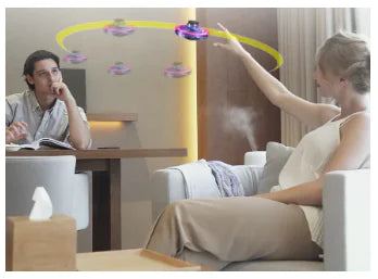 A woman interacts with an LED Flying Spinner Toy hovering above while a man observes, showcasing the fun of EDC fidget toys.
